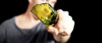 Мужчина держит перед собой разбитую бутылку
