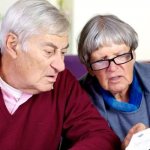 Пожилые люди изучают квитанцию